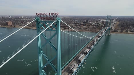 Logo-Der-Botschafterbrücke-Mit-Einer-Endlosen-Reihe-Von-Lastwagen,-Die-Die-Grenze-Zwischen-Den-USA-Und-Kanada-überqueren