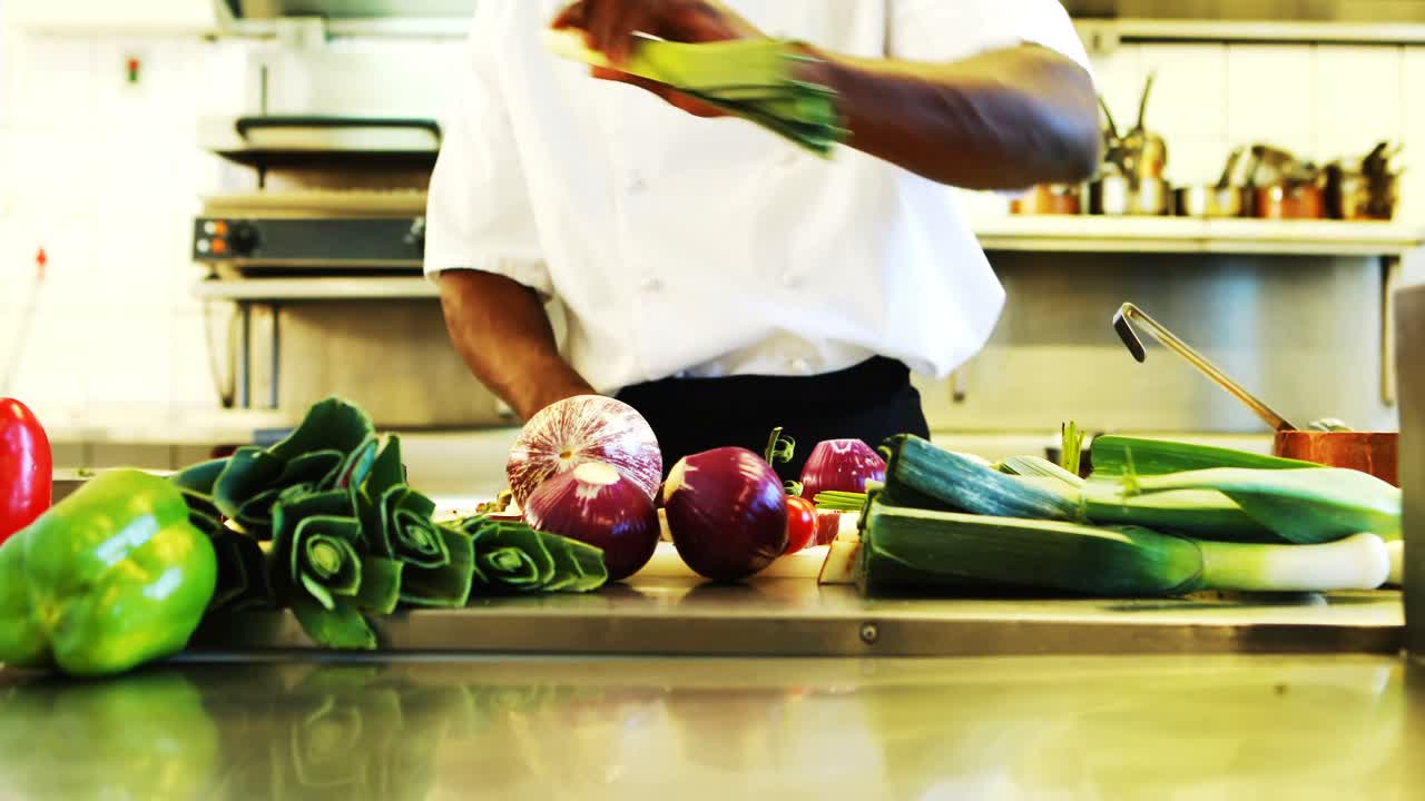Chef che taglia le verdure in una cucina professionale