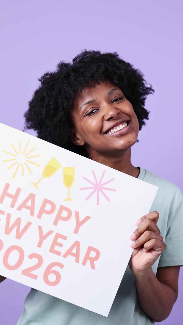 Donna nera gioiosa che tiene un cartello 'Felice Anno Nuovo 2026'