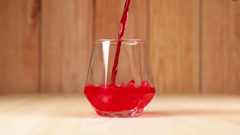 red drink poured into glass with ice