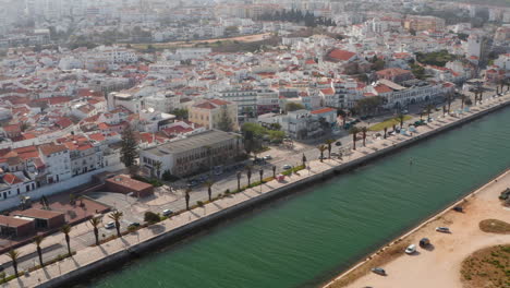 Aerial-view-of-Avenida-dos-Descobrimentos-street-in-Lagos,-Portugal,-drone-flying-sideways-tilting-up-reveal-city-landscape,-day