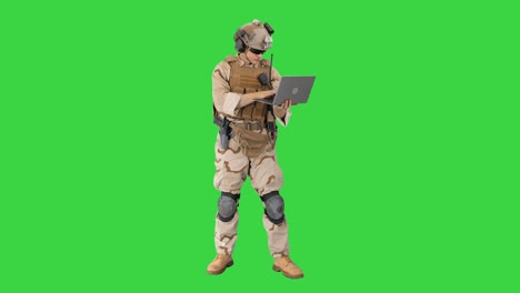 soldier standing and using laptop on a green screen, chroma key