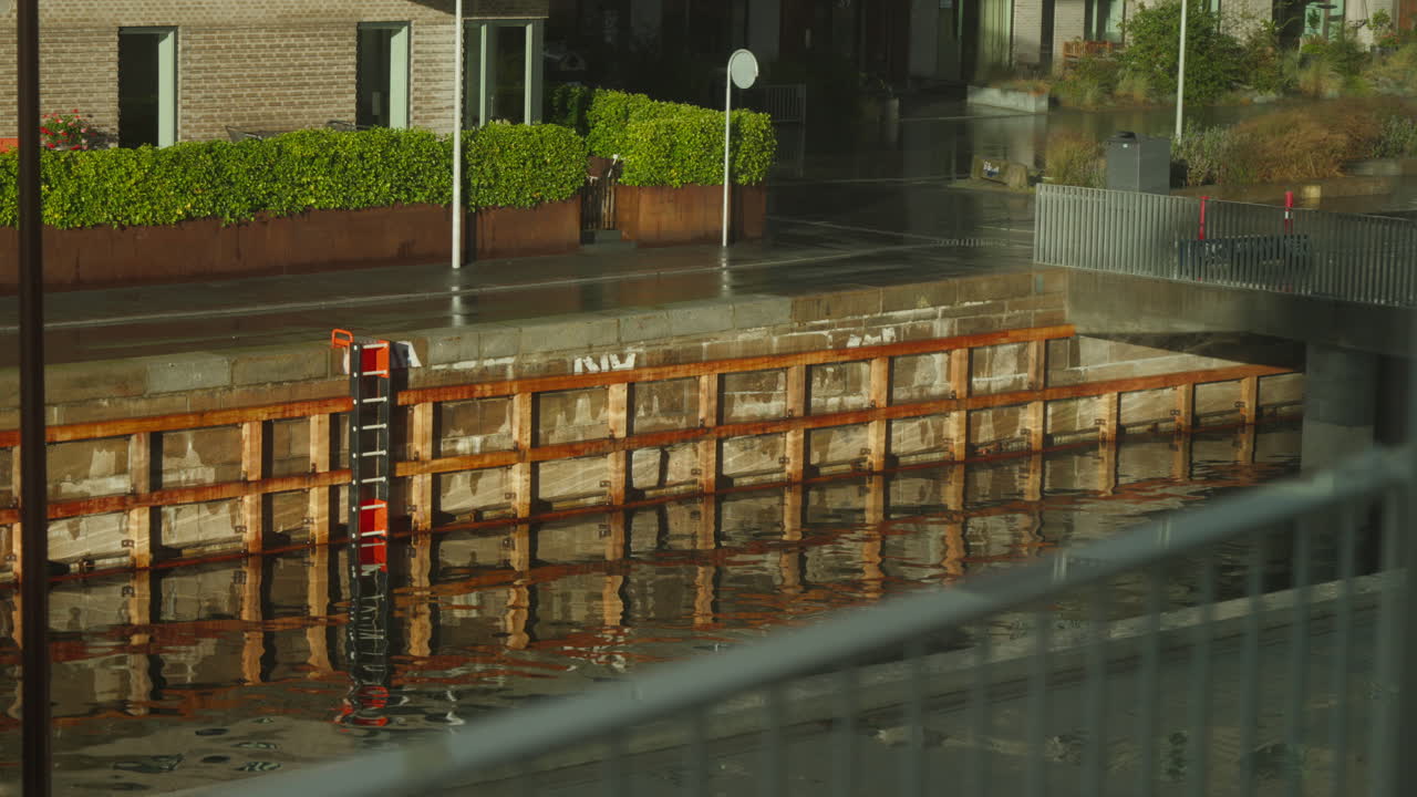 Sunlit urban canal with reflections, serene waterside scene. Perfect for travel or cityscape projects. Copenhagen, Denmark.