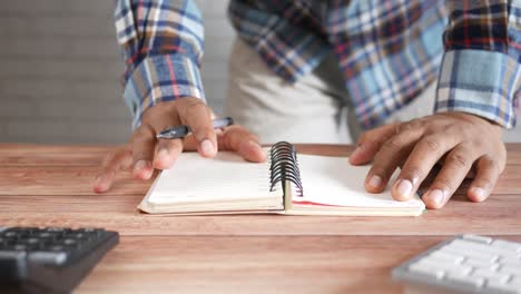 person writing in a notebook at a desk