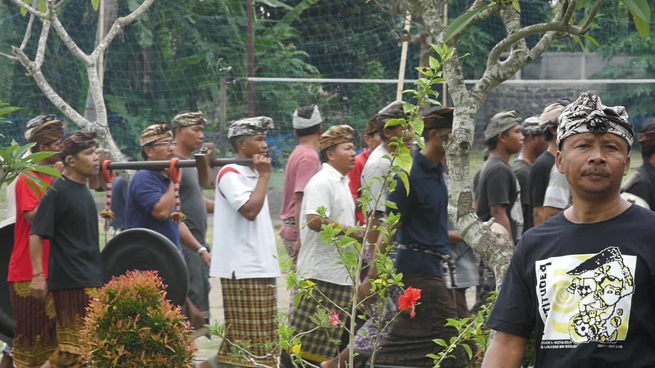 Balinese Men in Traditional Clothing Participate in a Cultural Ceremony