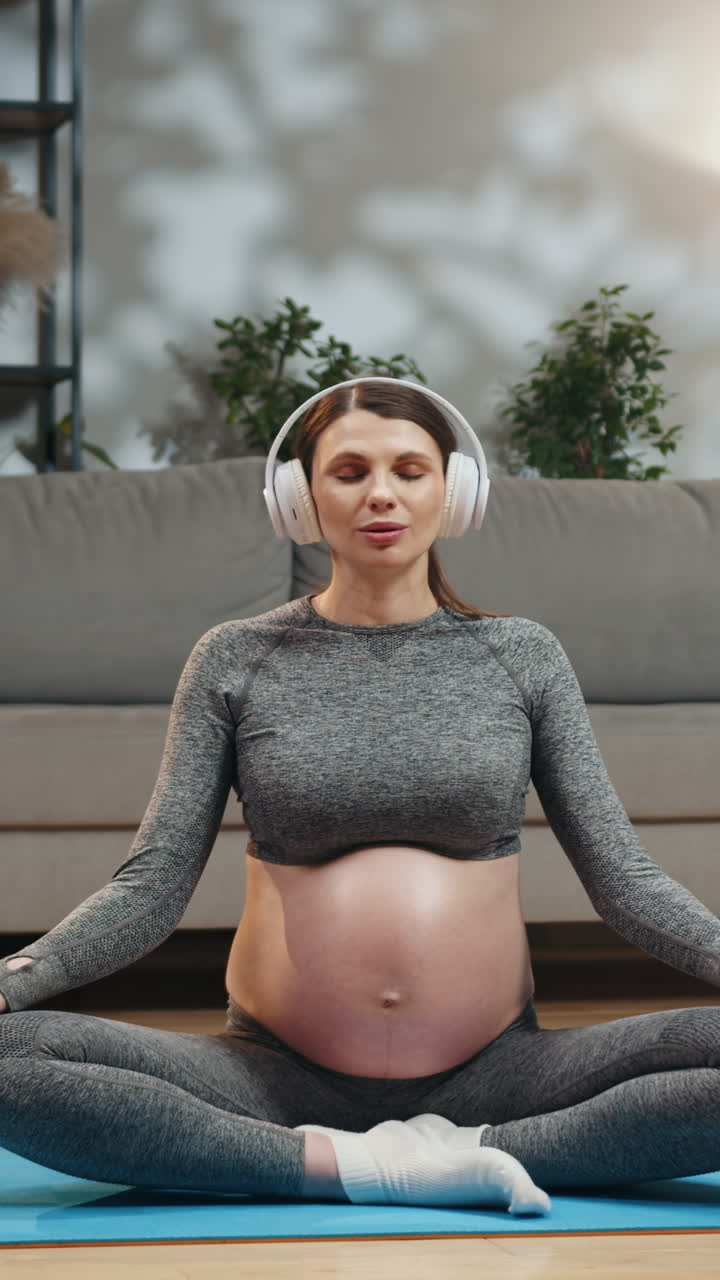 Young woman focused on laptop screen while working remotely from her cozy living room bathed in