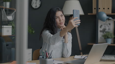 woman taking a selfie in a modern office