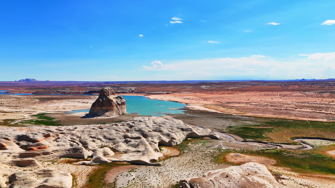 Solitary Lone Rock near the blue waterscape of Lake Powell. Vast panorama of Glen Canyon Recreation Area, Utah, USA from drone