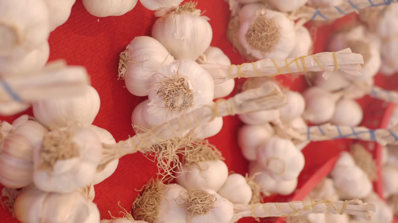 Close-up of garlic bulbs displayed on a red surface