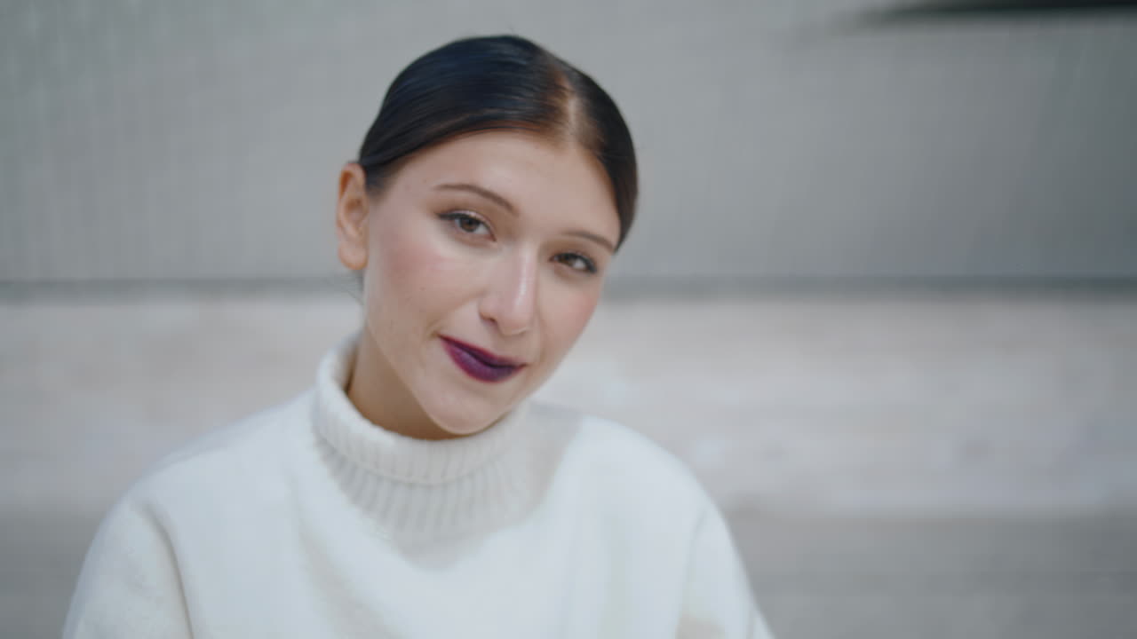 mujer linda sonriendo cámara sosteniendo pluma en la mano primer plano. joven juguetona posando