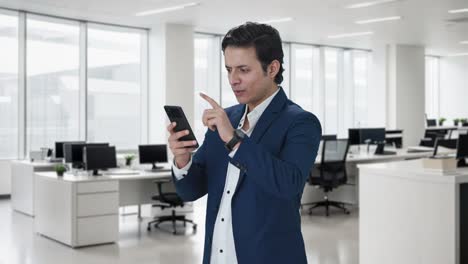 happy indian manager using mobile phone