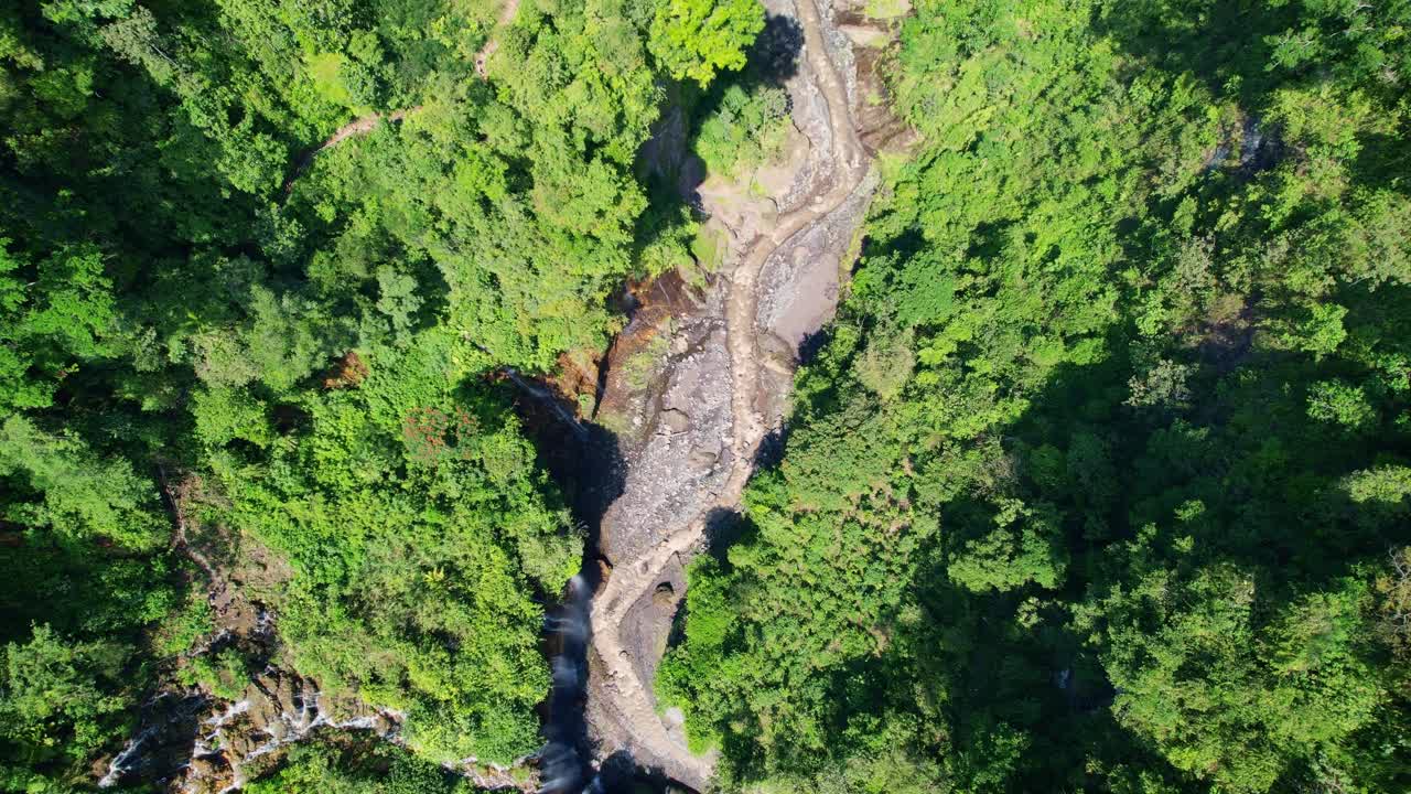 Aerial view of Tumpak Sewu waterfall, lush greenery in East Java, Indonesia