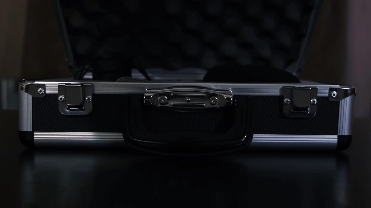 오디오 장비와 함께 검은 알루미 케이스를 열었습니다.