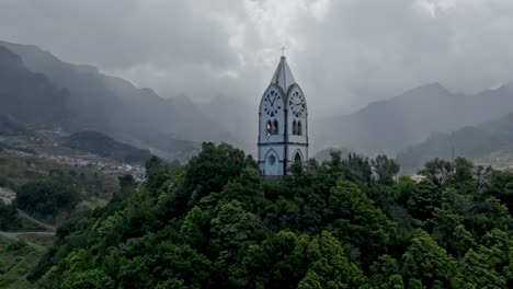 dramatic light rays between clouds frame church tower in madeira portugal