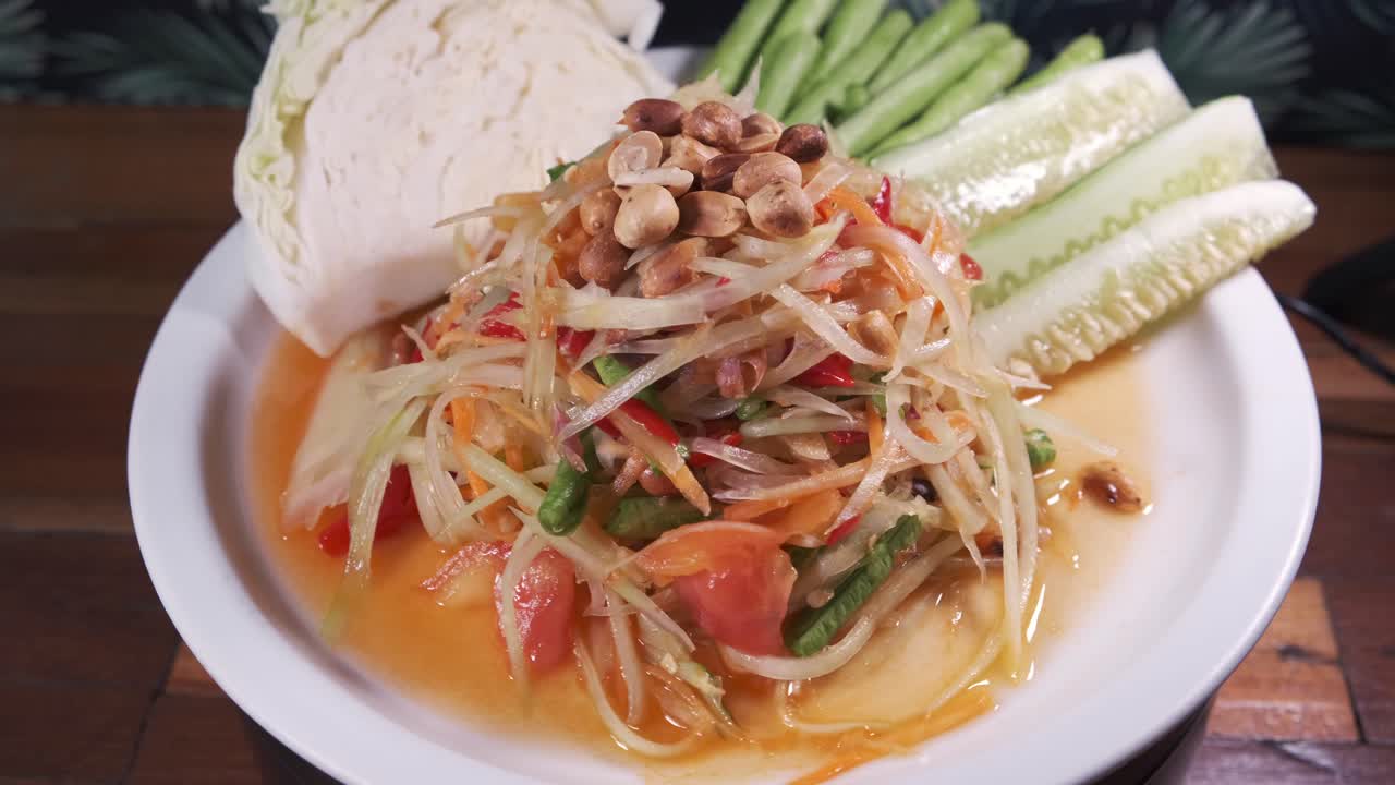 Cận cảnh món Somtam, gỏi đu đủ Thái Lan đích thực với nước sốt chua ngọt mới làm, đặt trên đĩa xoay màu trắng