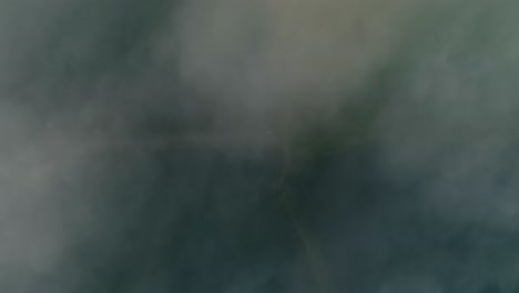aerial top-down rising over clouds. frydman, poland