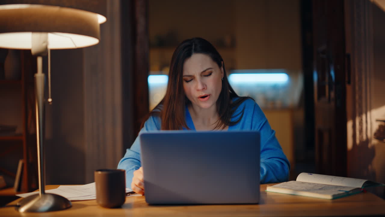 Stressed freelancer finish video call in night home holding documents closeup