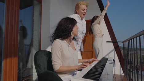 amigos bailando y tocando el piano en un balcón