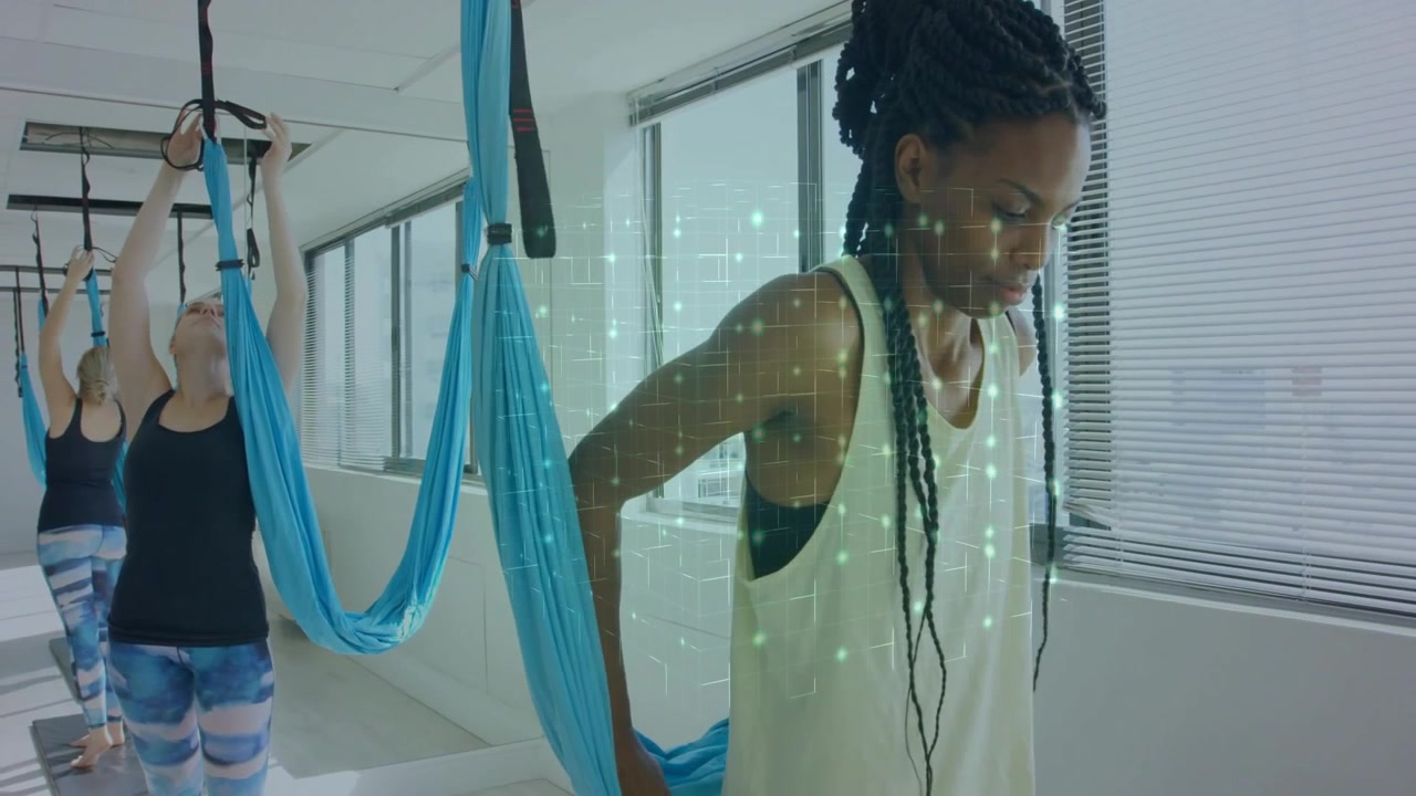 After securing silk at back, woman initiating yoga balance pose with green AR grid for fitness