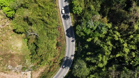 A-beautiful-road-winding-through-the-jungle-in-Songklaburi,-Thailand