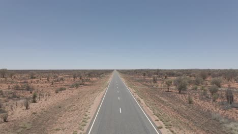 Lone-Woman-Walking-On-Remote-Asphalt-Road-In-Northern-Territory,-Central-Australia