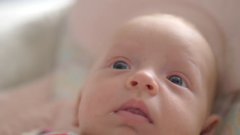 indoor portrait of two months baby girl with big blue eyes