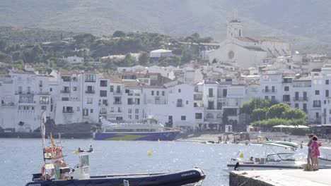 small coast town in costa brava, spain, white houses at the background, boats in foreground, static shot