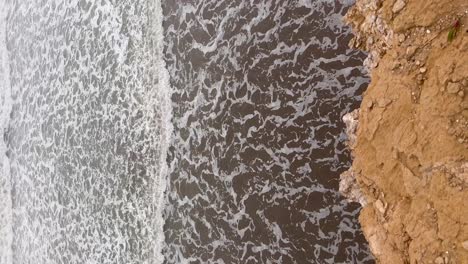 waves crashing on the rocky argentinian coast, aerial view