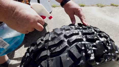 Spraying-soap-on-a-lawn-tire-to-find-a-leak