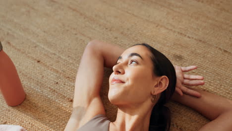 una mujer relajándose en una alfombra de yoga.