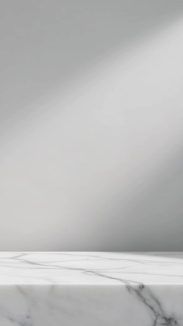 Clean white marble display surface with diagonal shadows against a light grey background.