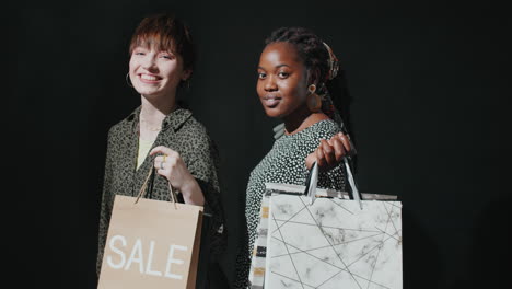 Beautiful-Multiethnic-Girls-Smiling-and-Posing-with-Shopping-Bags-in-Studio