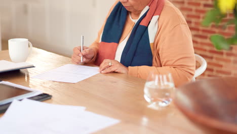 senior woman signing documents at home