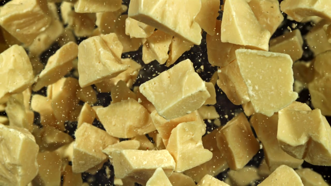 Close-up of Cocoa Butter Chunks Falling in Super Slow Motion