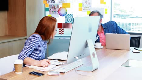 hombres y mujeres ejecutivos que trabajan juntos en el escritorio