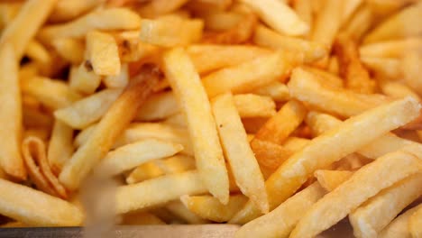 una pila de patatas fritas doradas y crujientes.