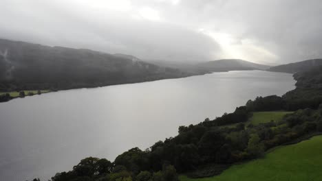 Toma-Panorámica-Aérea-A-La-Izquierda-Del-Lago-Tummel-En-Escocia-Con-Los-Rayos-Del-Sol-Reflejándose-En-El-Agua.