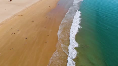 Large-beach-in-a-sunny-winter-day-with-a-few-people-walking-around