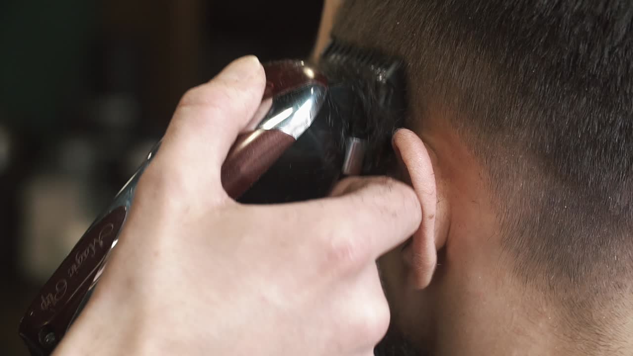 Close-up of a barber cutting a client's hair with a hair clipper