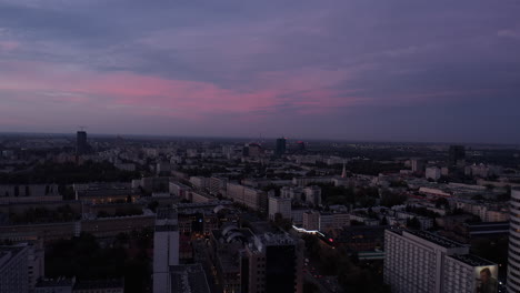 Forwards-fly-above-dimmed-urban-neighbourhood-at-twilight.-Low-light-evening-city-scene.-Warsaw,-Poland