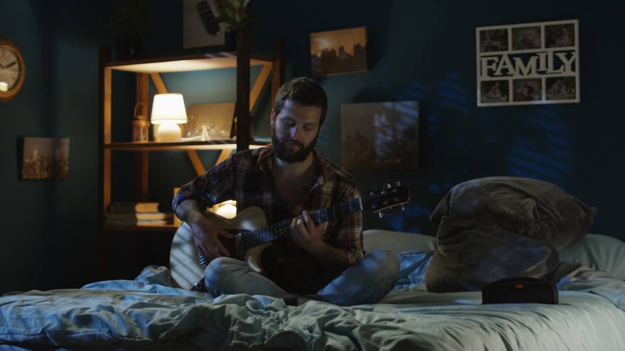 Couple Singing and Playing Guitar in Bedroom at Night