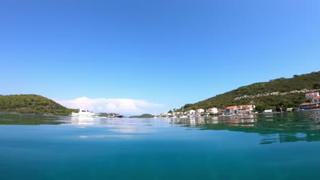 a small boat approaches village polace, island mljet in croatia. it is a beautiful sunny day and the view is from sea level.