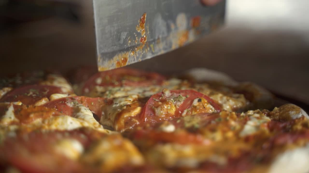 Cutting hot smokey delicious homemade pizza in wooden plank close up Slow Motion 60FPS