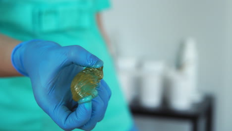 close - up of hands in rubber gloves to knead sugar for hair removal fingers for sugaring