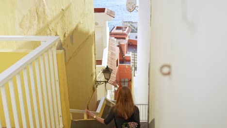 attractive woman walking down narrow street towards ocean in puerto de santiago