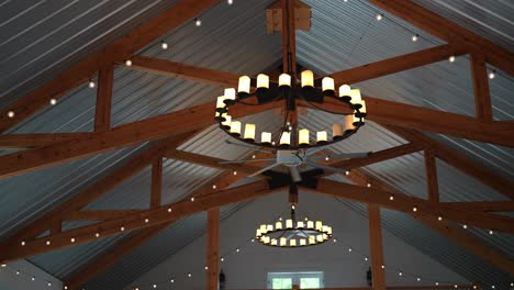 Inside-a-barn,-begins-with-an-overhead-view-showcasing-captivating-wheel-shaped-lights-suspended-from-the-ceiling