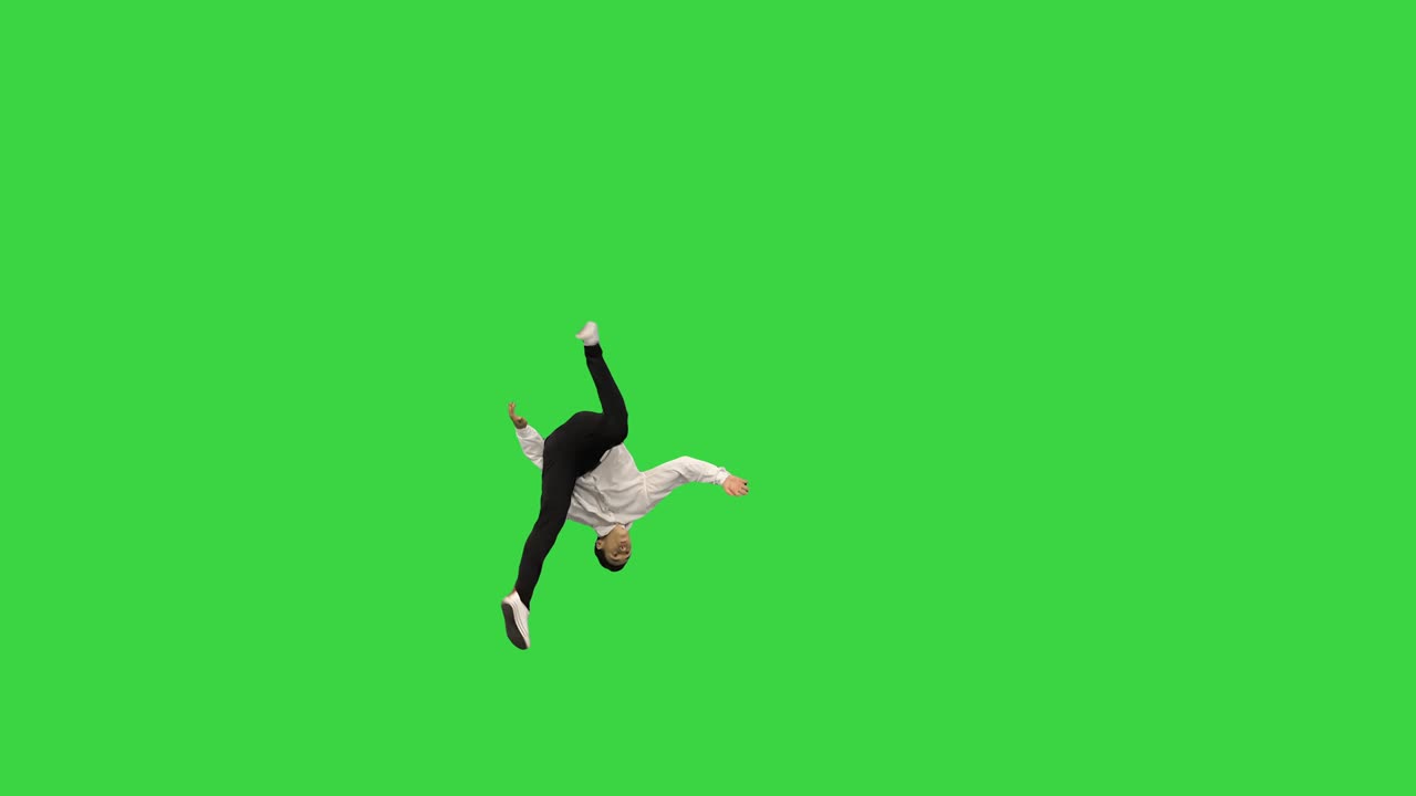 Giovane uomo in camicia bianca che fa un salto mortale all'indietro, guarda la telecamera e si allontana su uno schermo verde, Chroma Key.