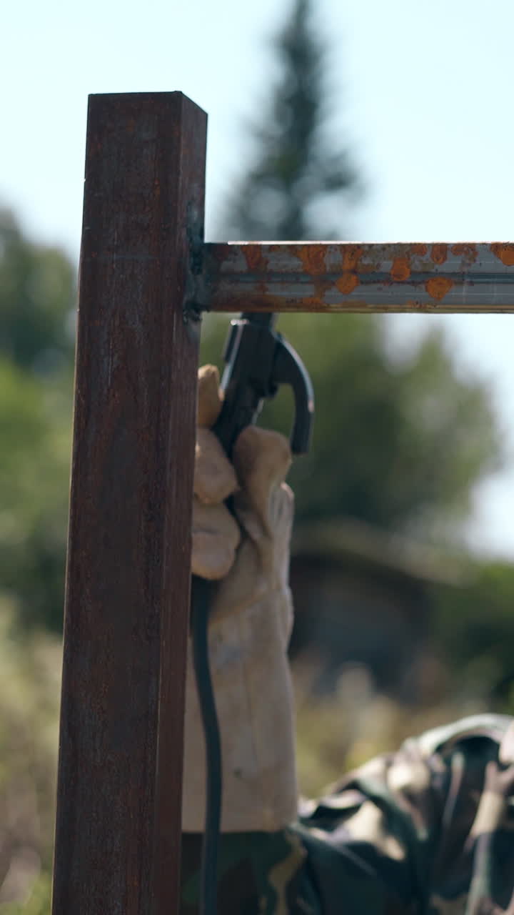 professional welder in protective mask fixes parts of future fence with modern equipment against clear sky
