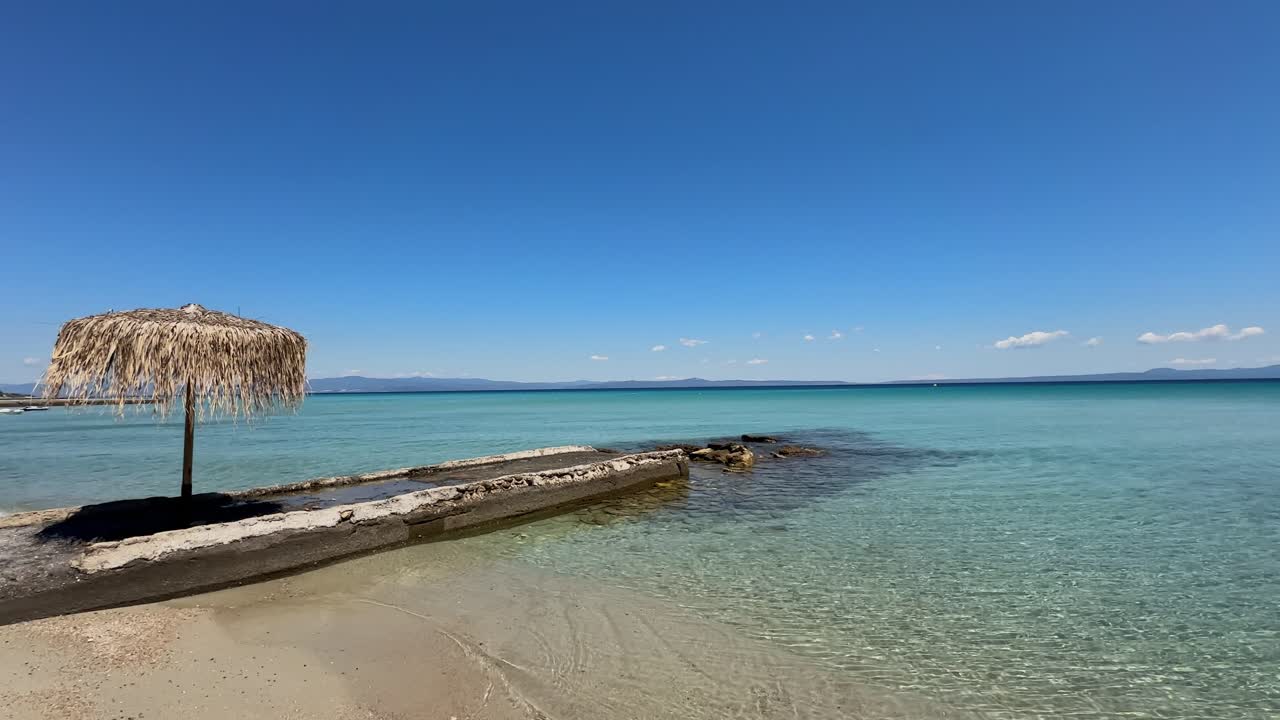 Stunning beach scene in Halkidiki, Greece, with elegant sunbeds facing the crystal-clear turquoise sea. A perfect summer escape in the heart of the Aegean.