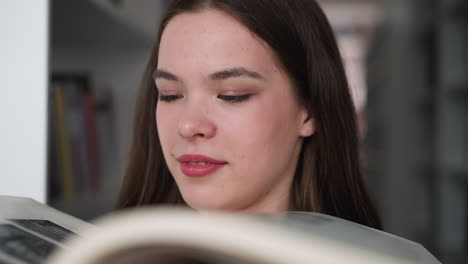 woman studies old photo album in library closeup. smiling lady looks at open book with monochrome pictures in archive room. history learning